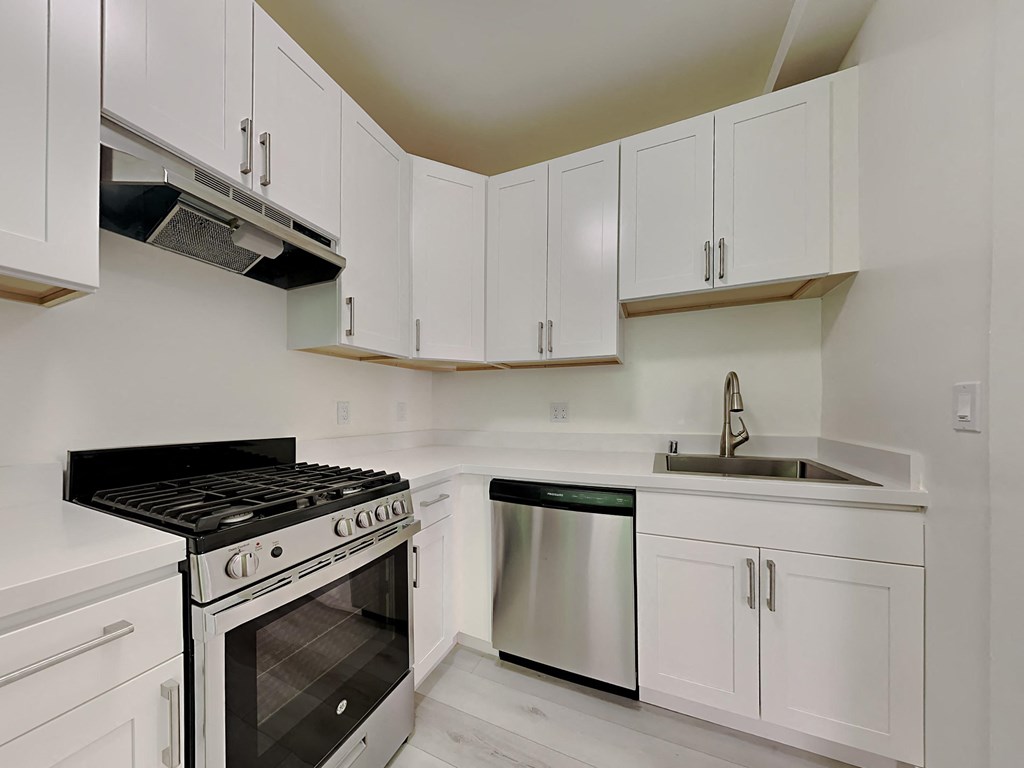 a kitchen with white cabinets and stainless steel appliances