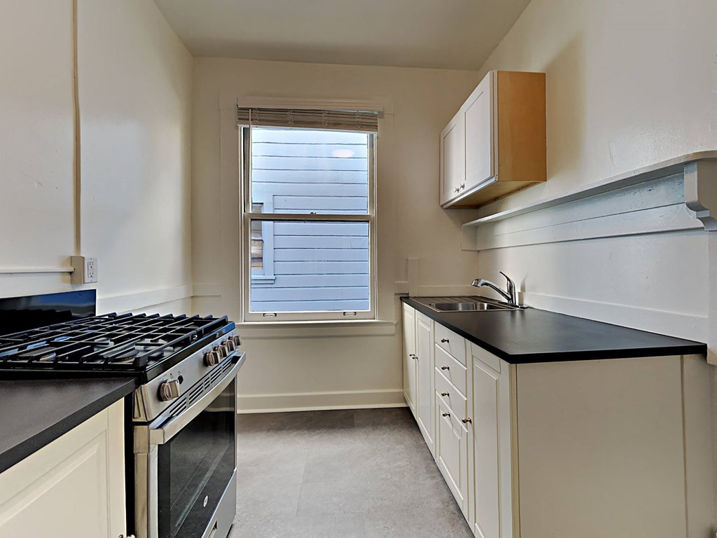 a kitchen with a stove and sink and a window