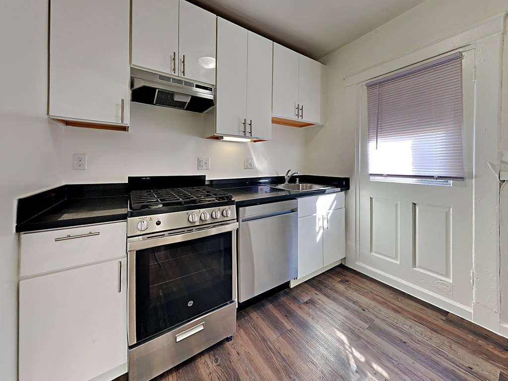 a kitchen with white cabinets and stainless steel appliances