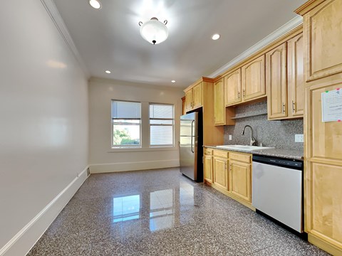 an empty kitchen with wooden cabinets and black appliances