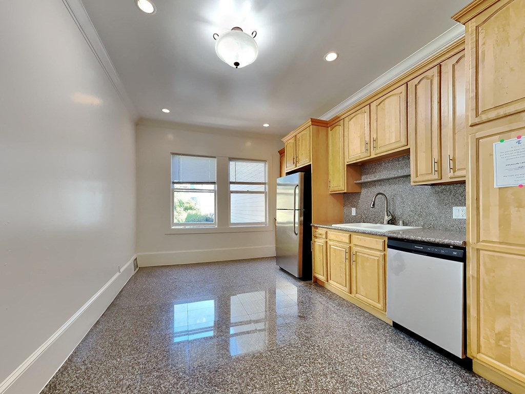 an empty kitchen with wooden cabinets and black appliances