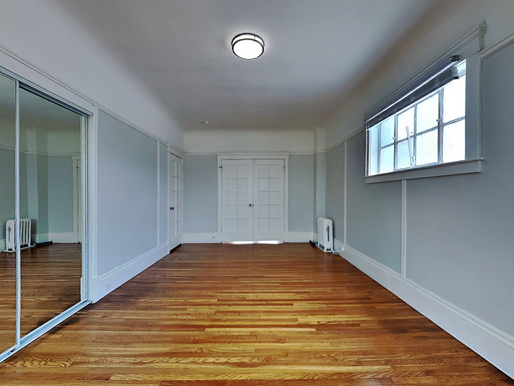 a room with a wooden floor and a window and a door