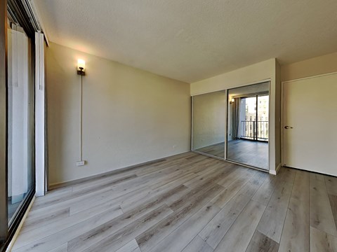 an empty living room with wood floors and a sliding glass door