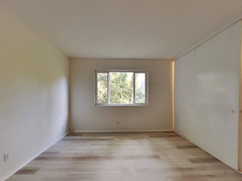 an empty room with white walls and a window
