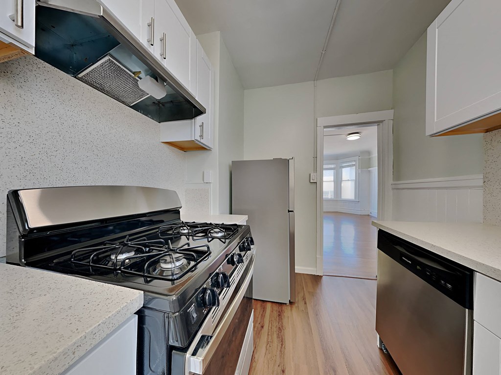 an empty kitchen with a stove and a refrigerator