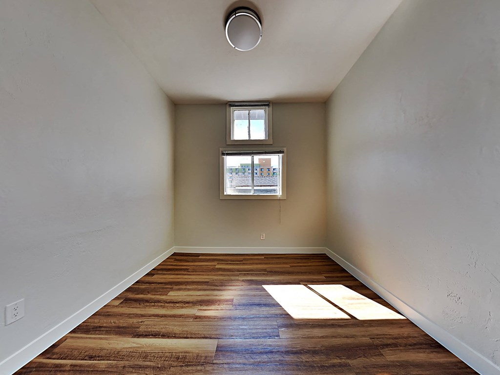 an empty room with wood floors and a window