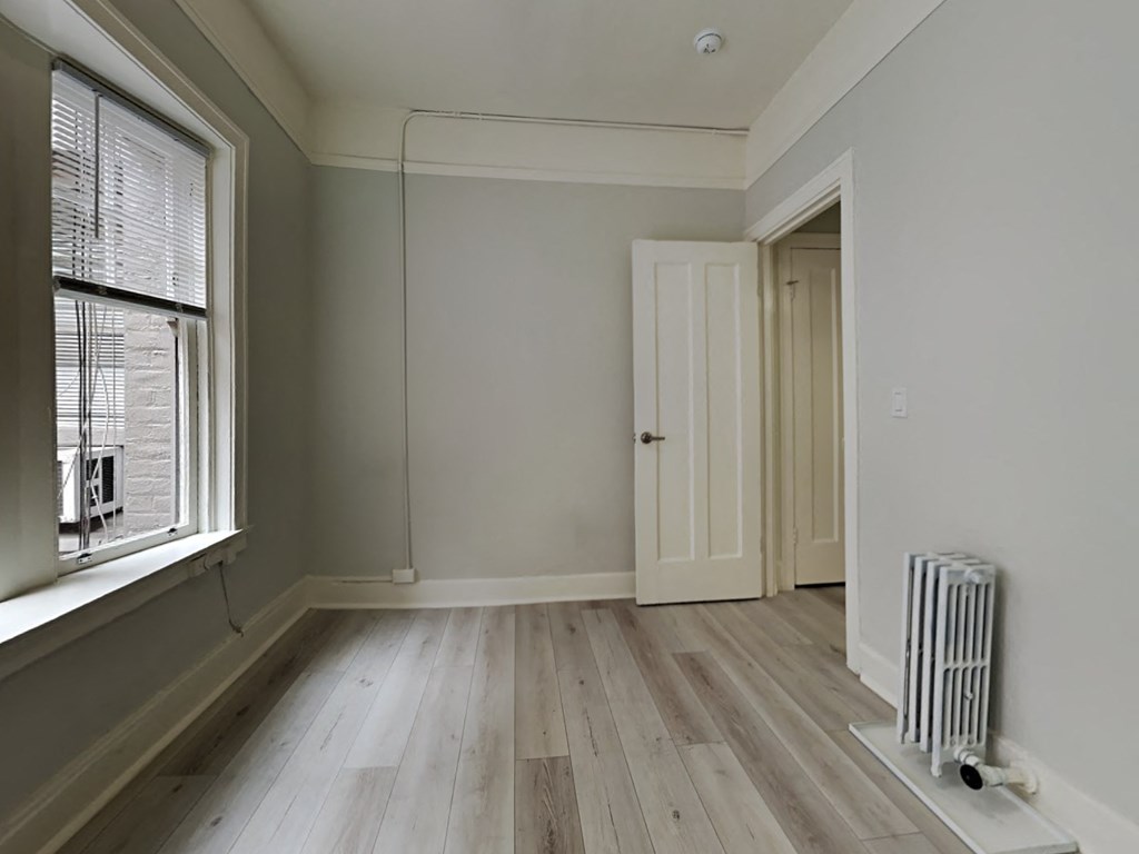 an empty room with a radiator and a window