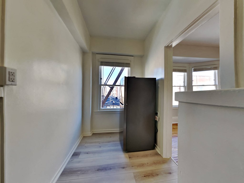 a large empty room with a large window and a wooden floor