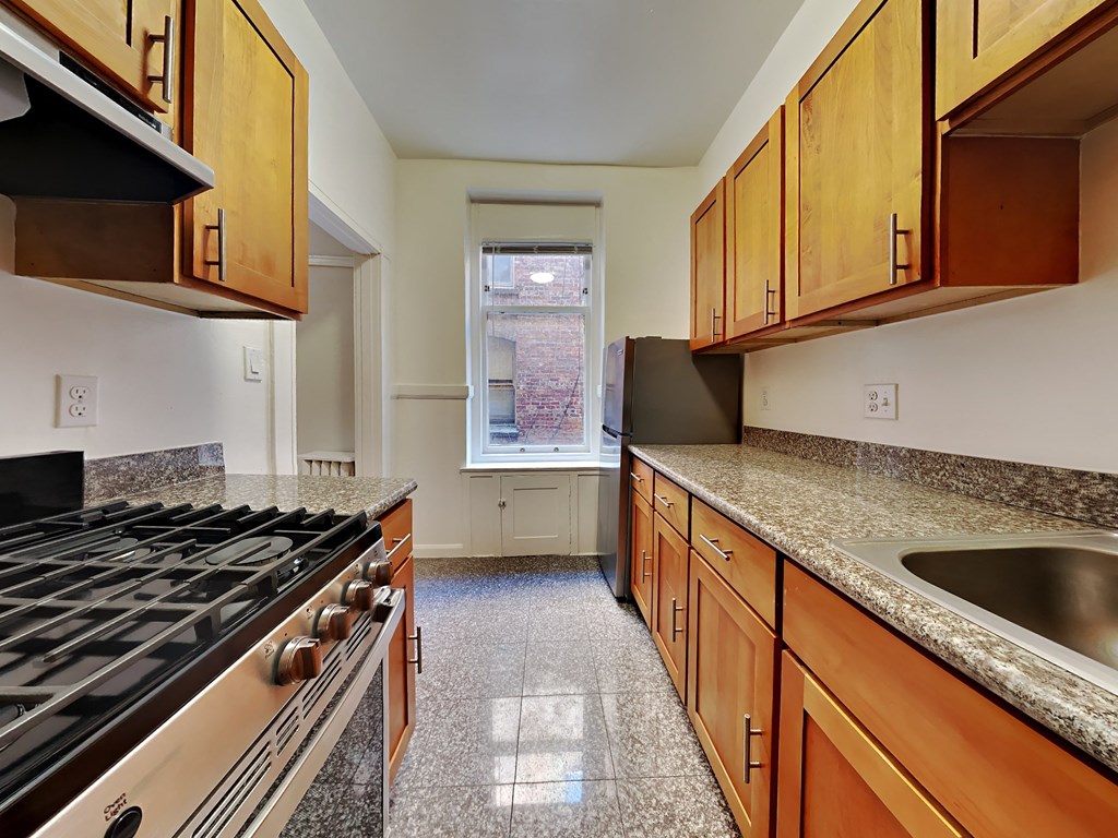 a kitchen with granite counter tops and wooden cabinets and a stove top oven
