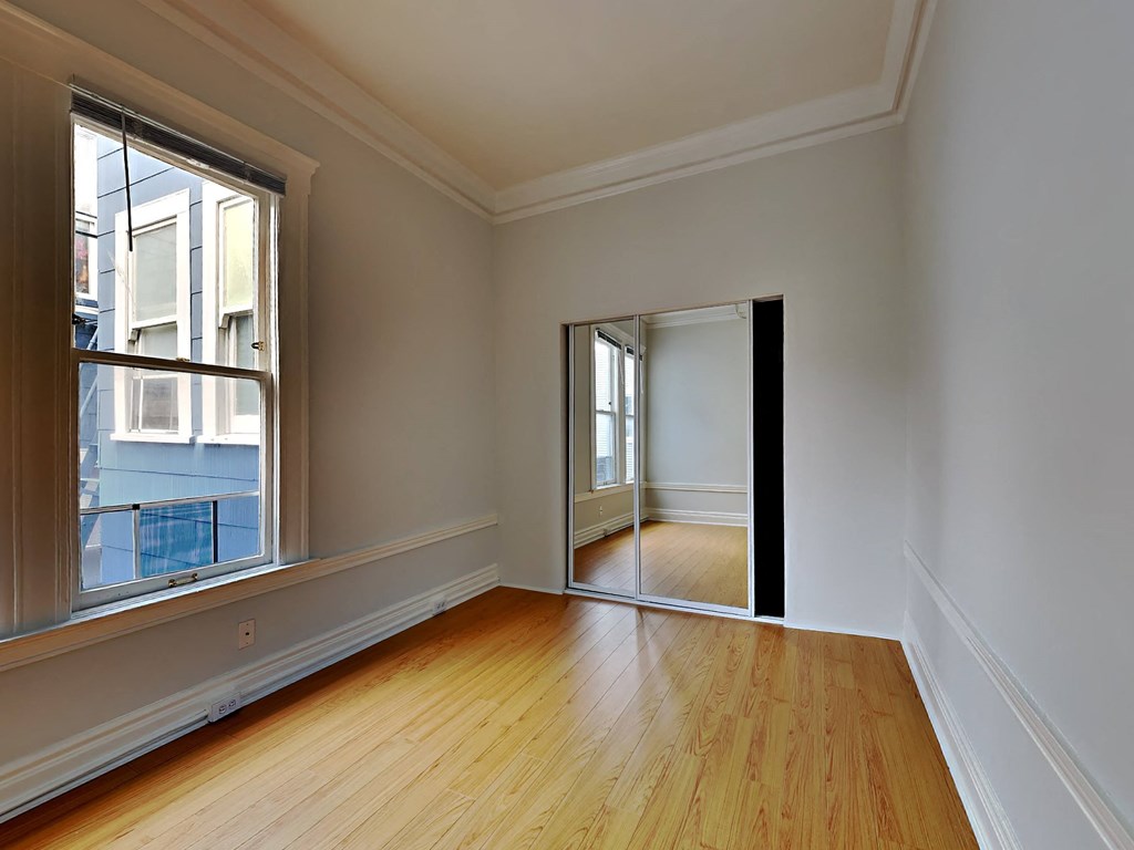 a living room with a hard wood floor and a large window