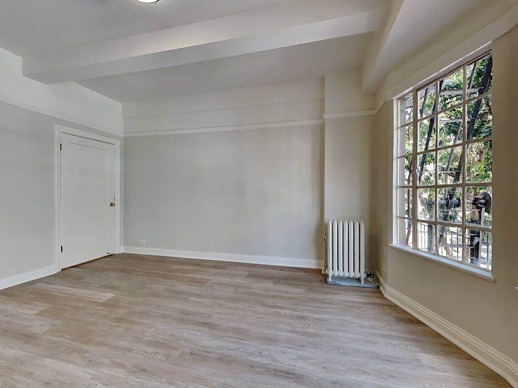 an empty room with a radiator and a window
