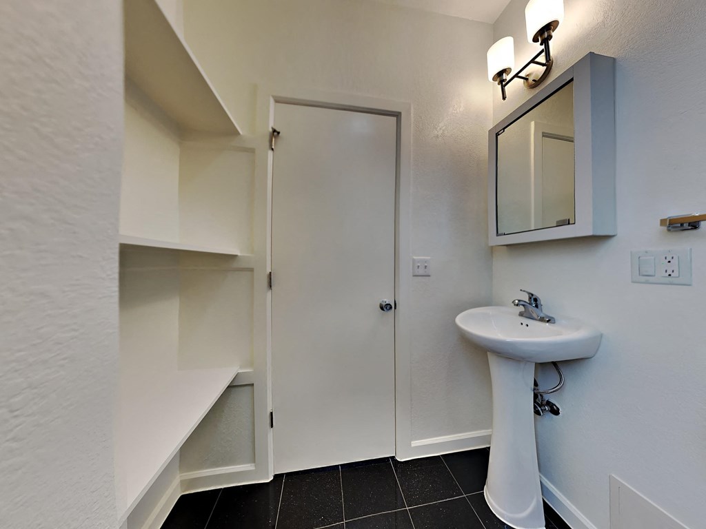 a bathroom with a sink and a shower and a mirror