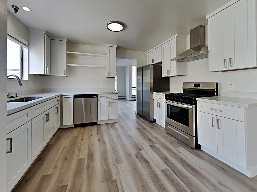a kitchen with white cabinets and stainless steel appliances