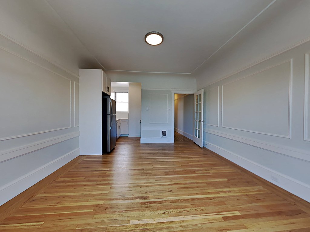 a living room with white walls and a wooden floor
