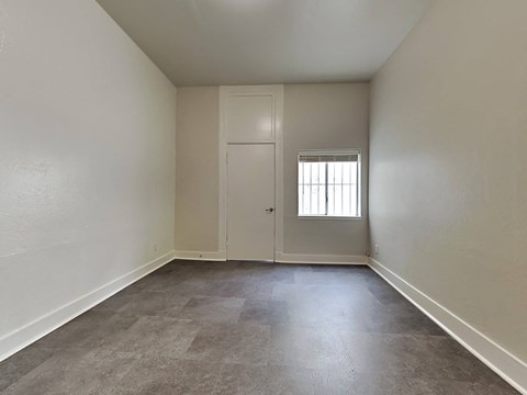 a empty living room with white walls and a window