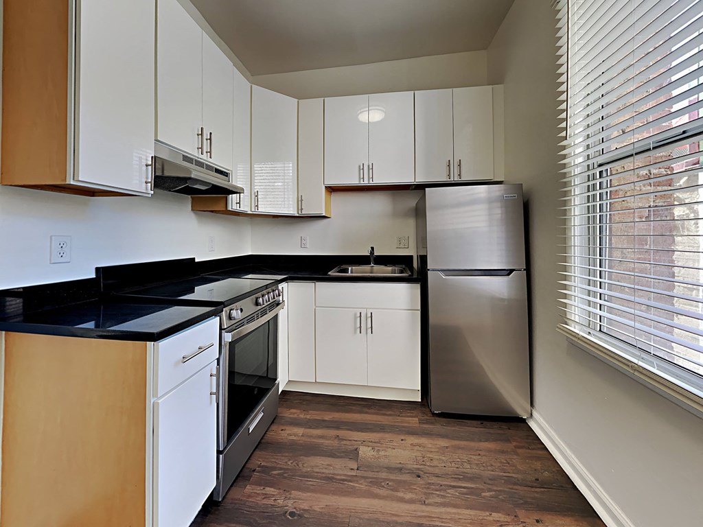 a kitchen with white cabinets and a stainless steel refrigerator
