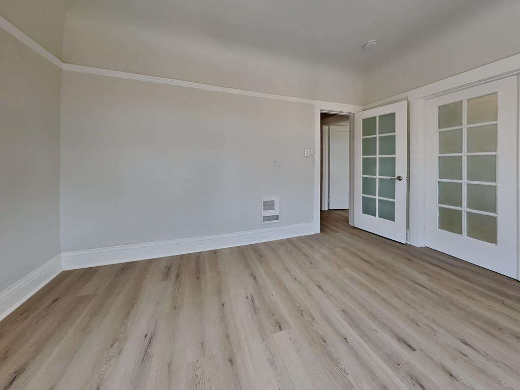a living room with white walls and wood floors