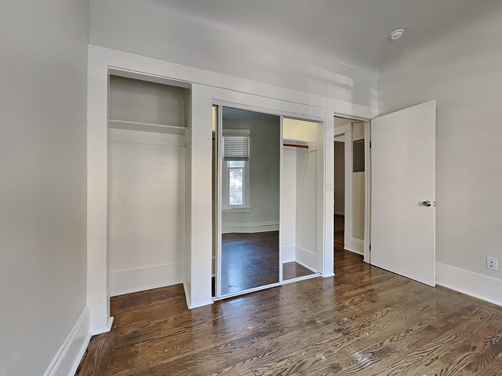 a living room with a wood floor and sliding glass doors