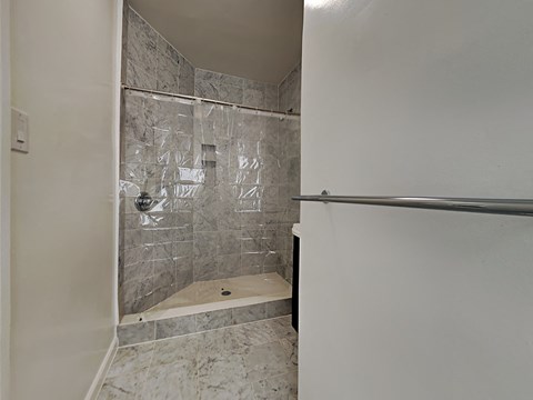a walk in shower in a bathroom with a glass door