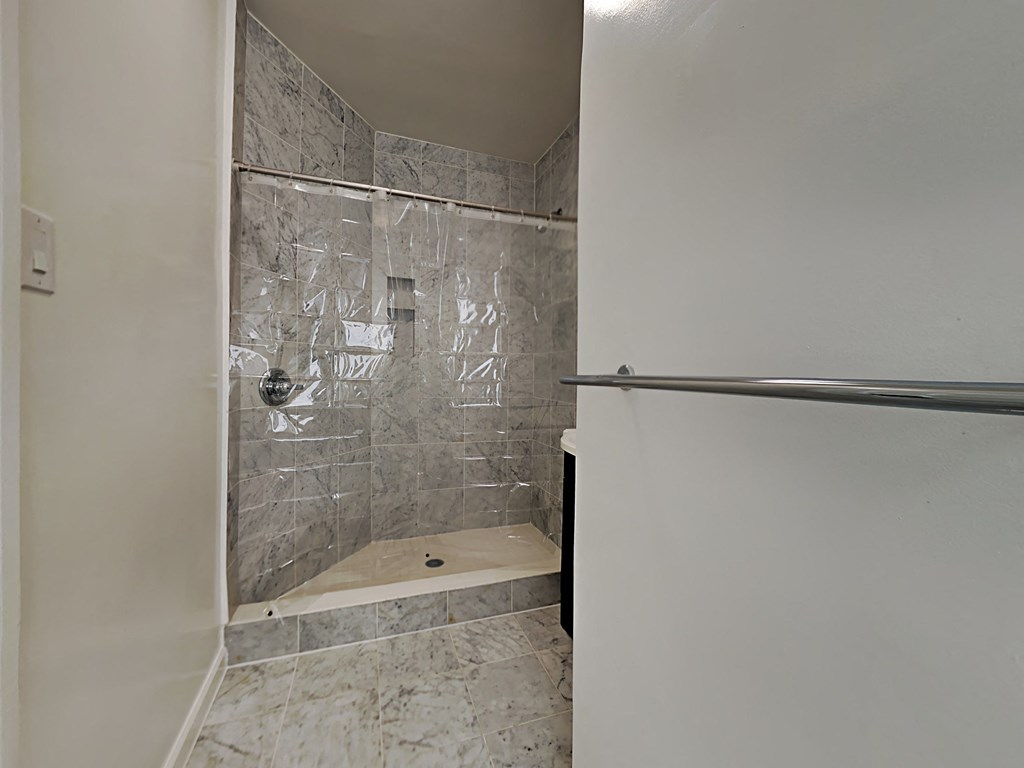 a walk in shower in a bathroom with a glass door