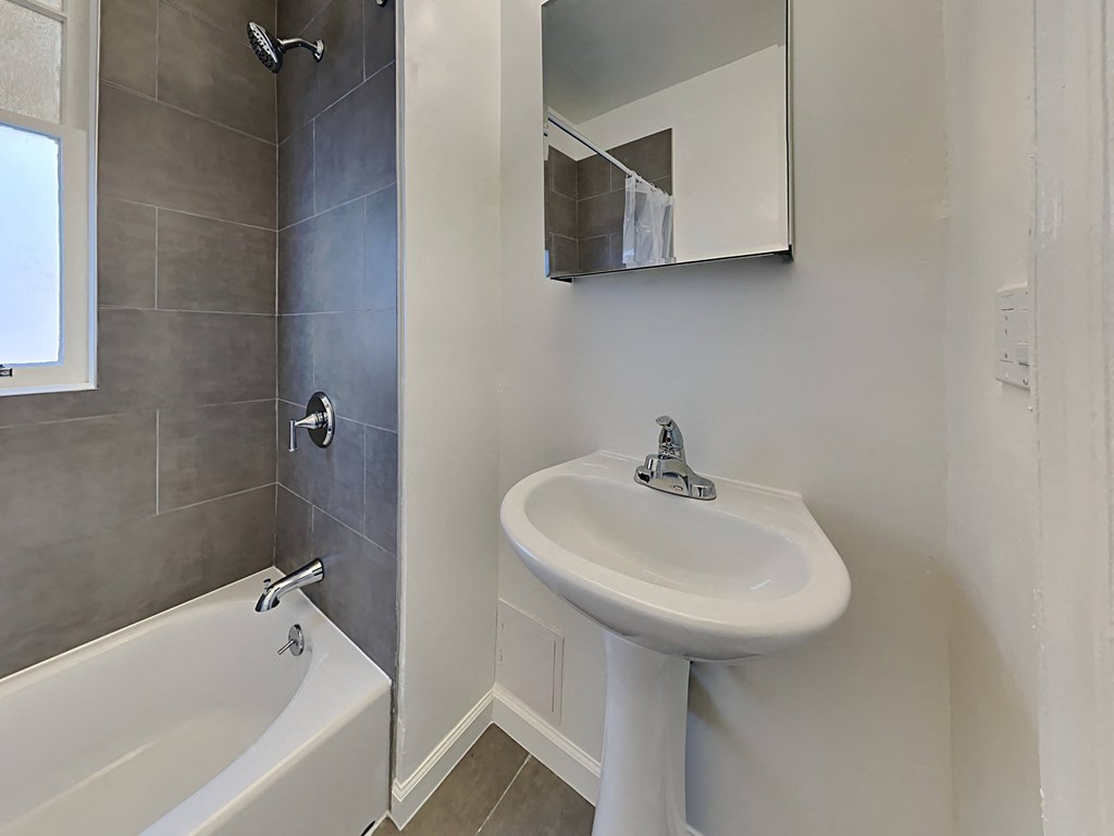 a bathroom with a sink and a tub and a mirror