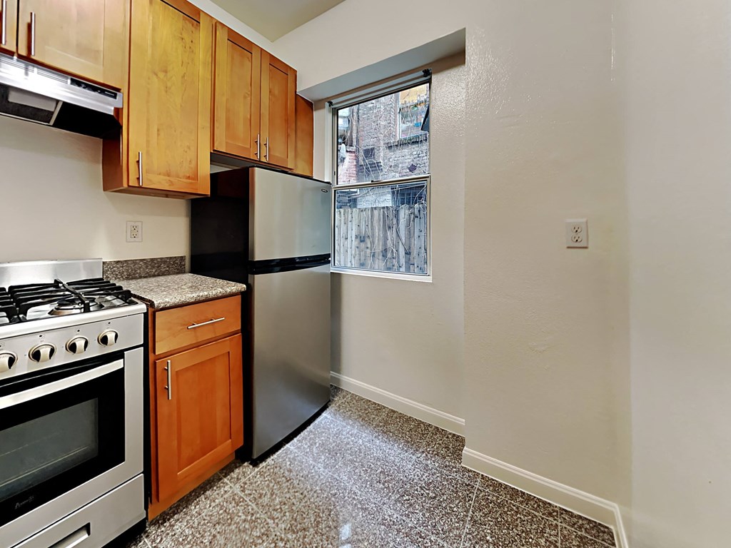 a kitchen with a stove refrigerator and a window