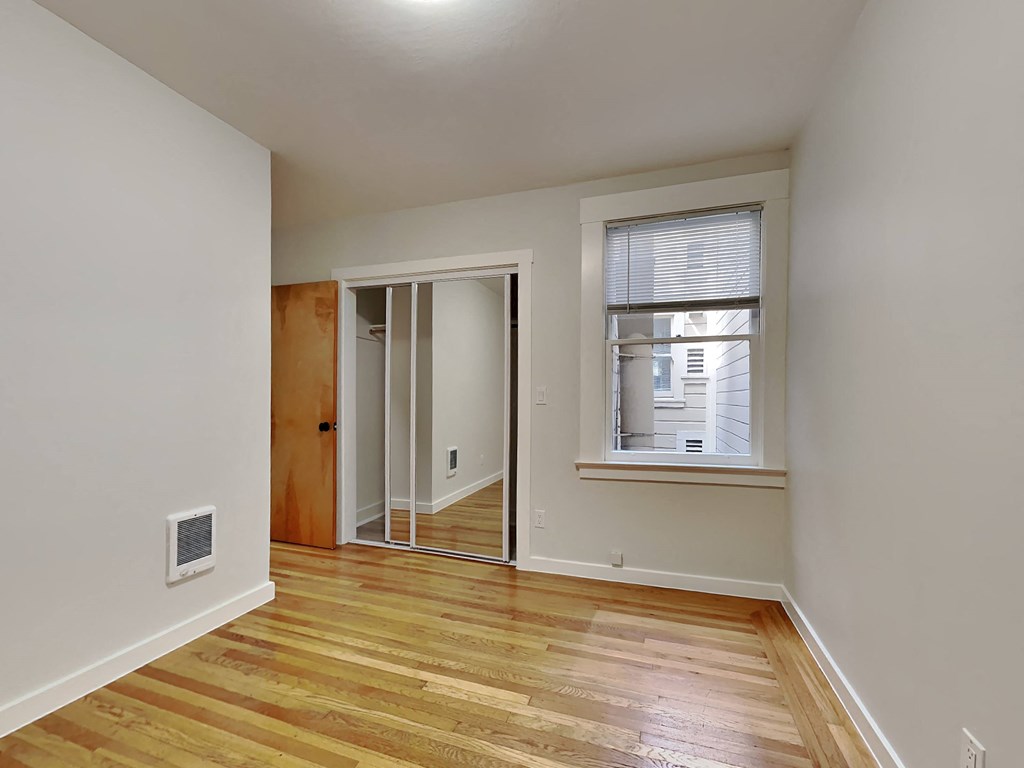 a living room with a hardwood floor and a window