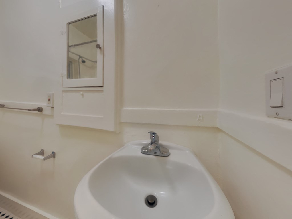 a white bathroom with a sink and a mirror