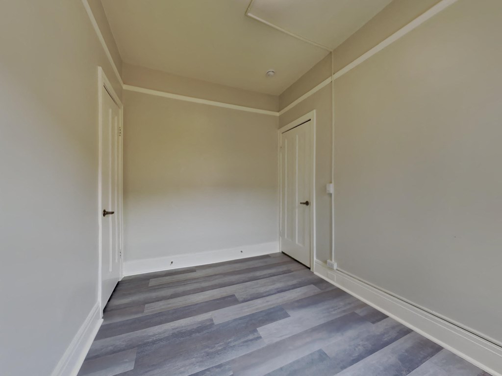 a room with wood floors and white walls and doors