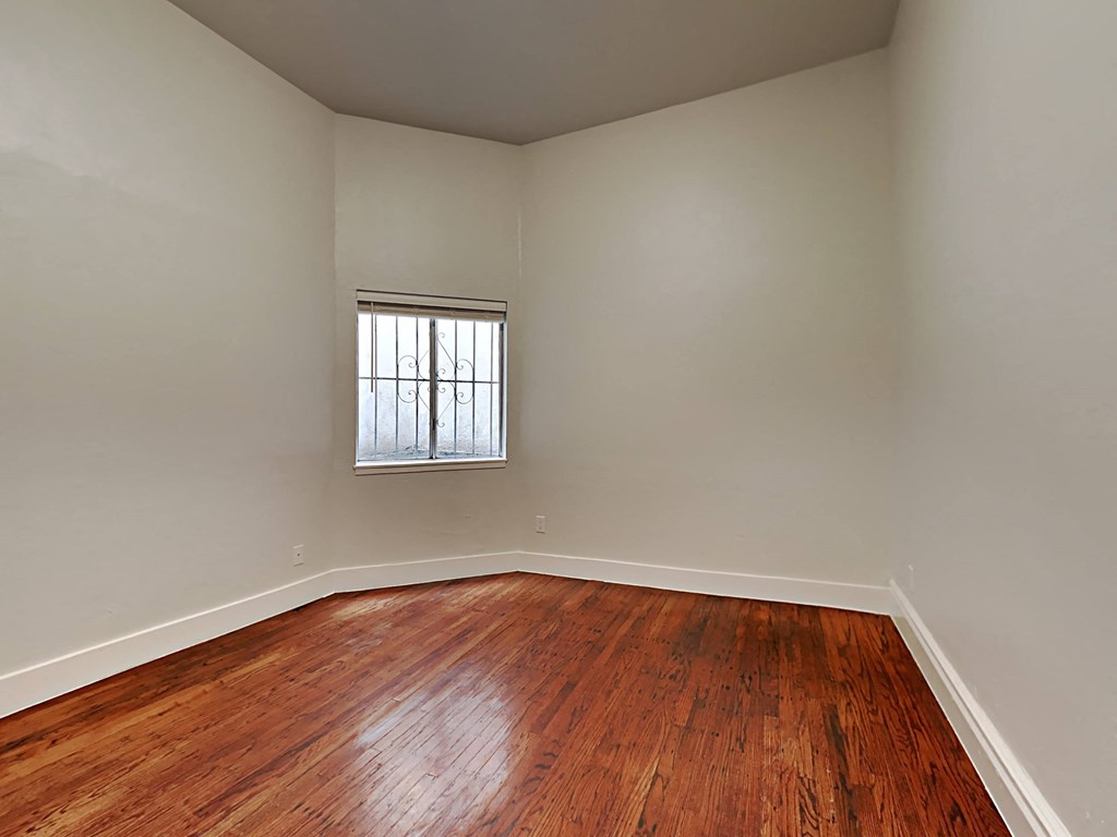 a empty living room with wood floors and a window