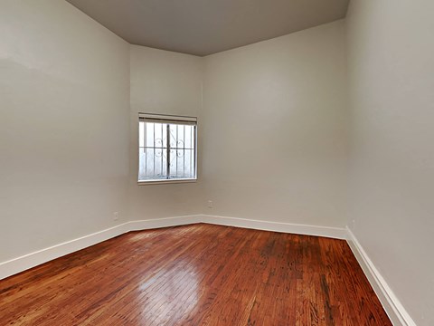 a empty living room with wood floors and a window