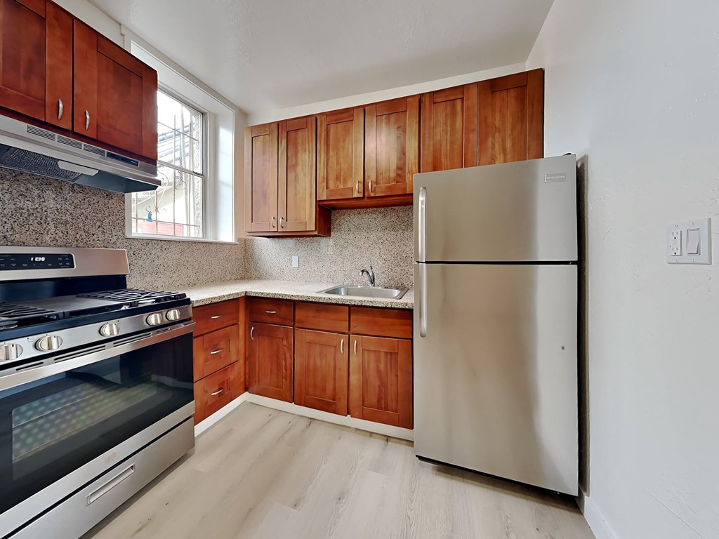 a kitchen with wooden cabinets and a stainless steel refrigerator
