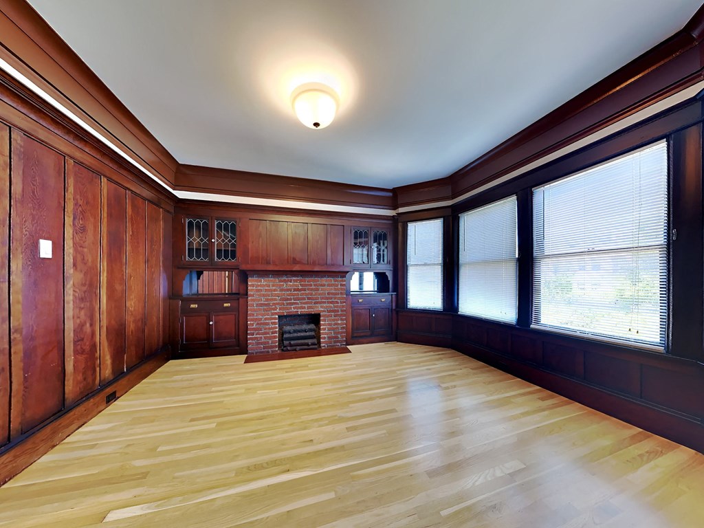 a living room with a fireplace and wooden floors and walls
