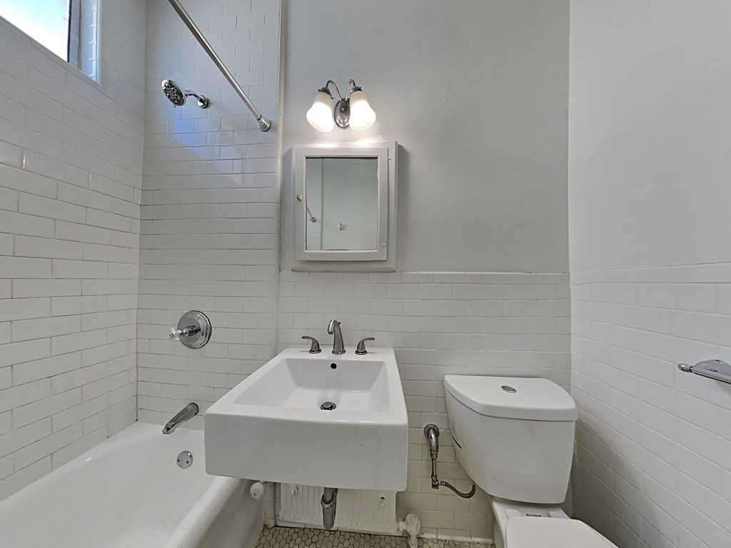 a white bathroom with a sink toilet and tub