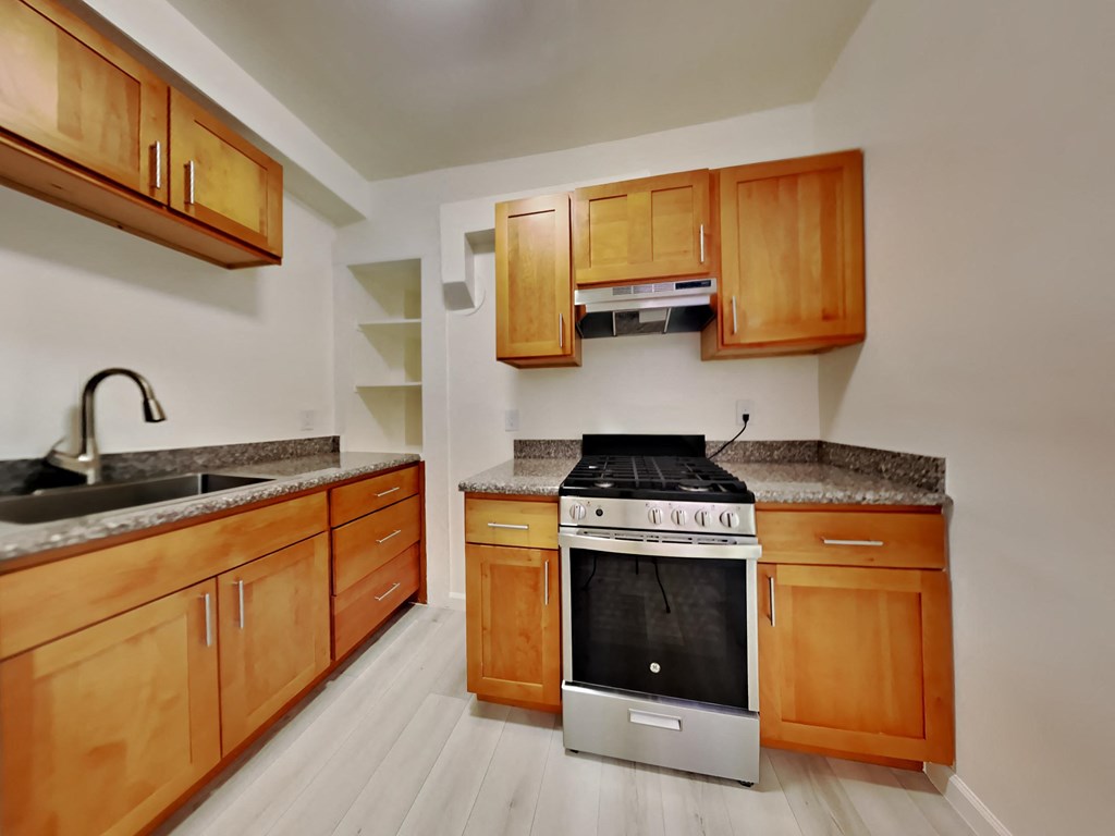 a kitchen with wooden cabinets and a stove and a sink