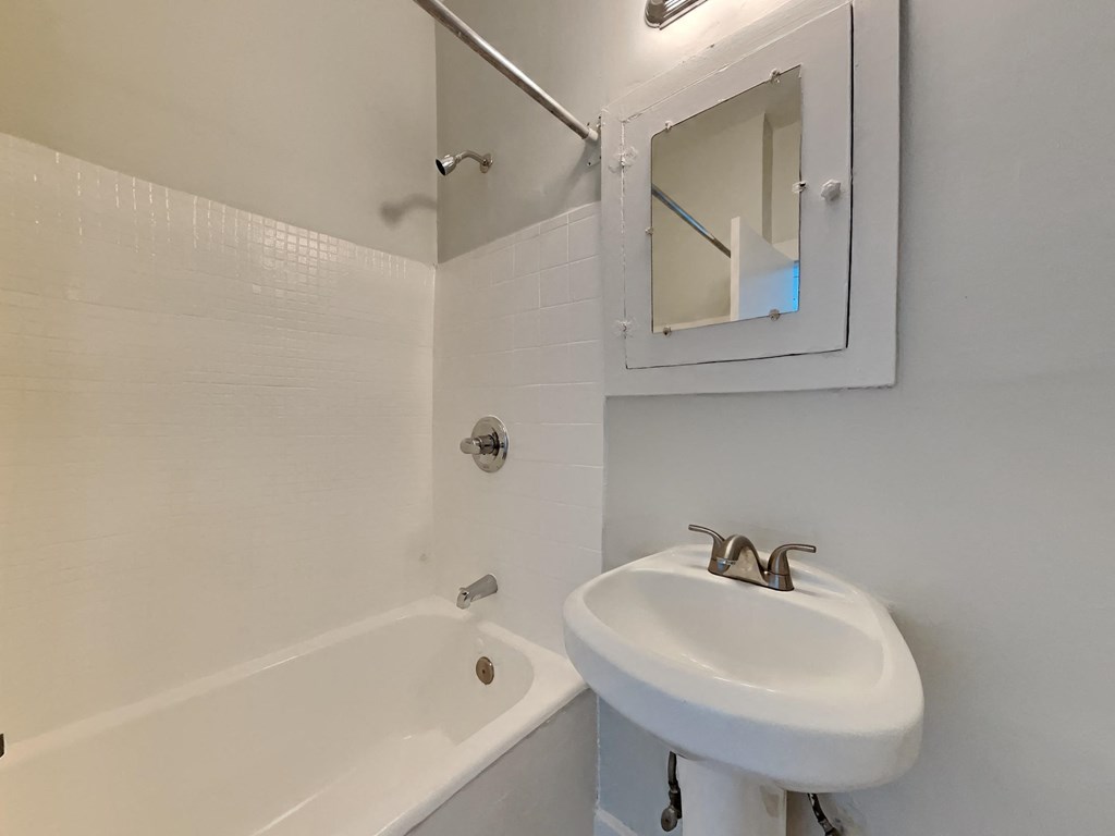 a bathroom with a sink and a tub and a mirror