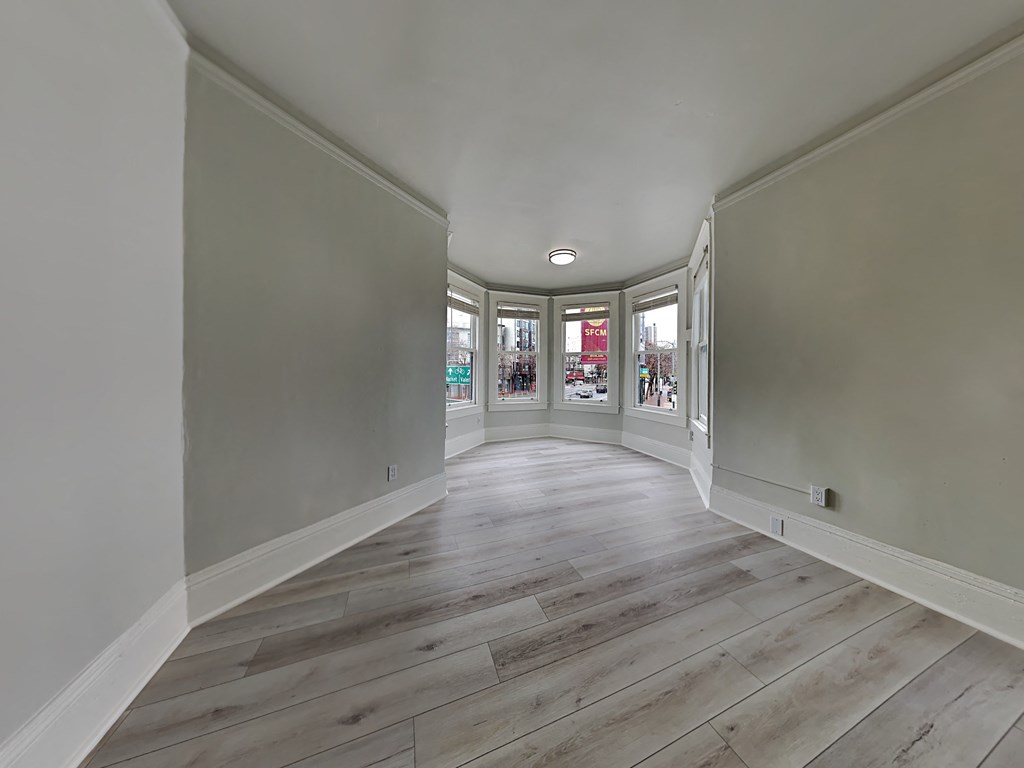 a living room with white walls and wood floors