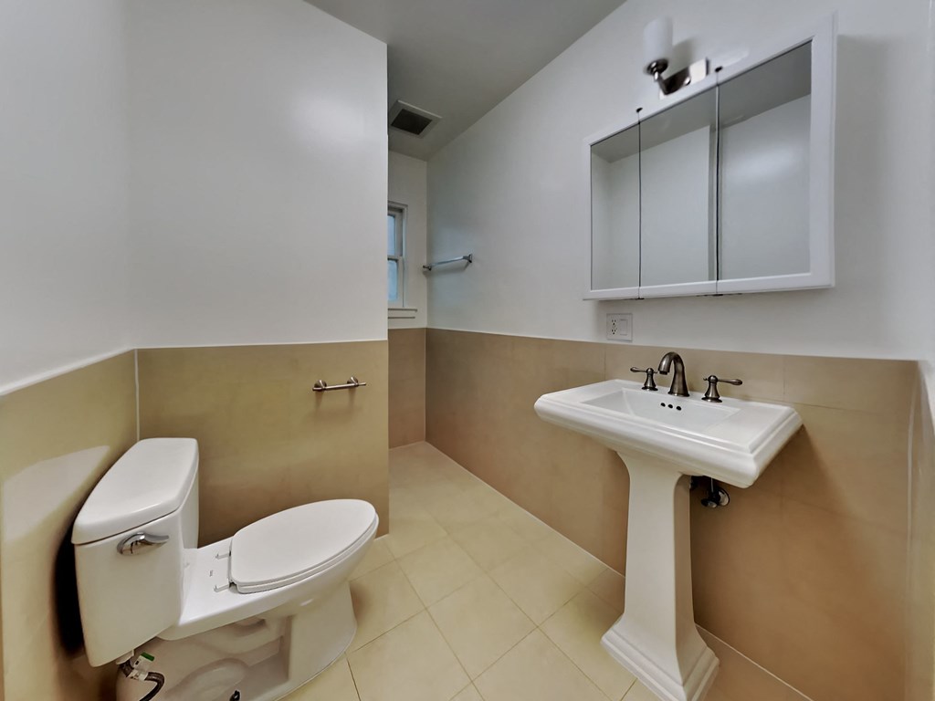 a bathroom with a toilet and a sink and a mirror