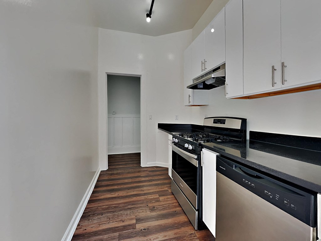 a kitchen with black counter tops and stainless steel appliances