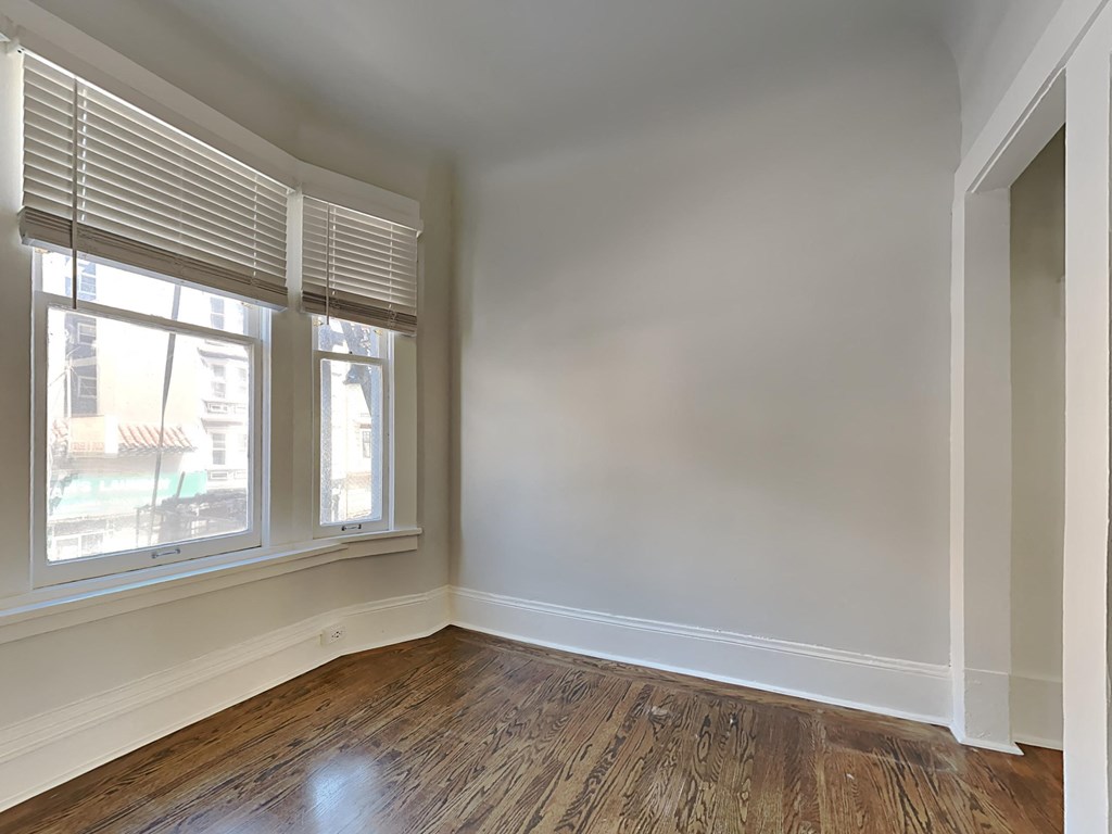 an empty room with wood floors and a window