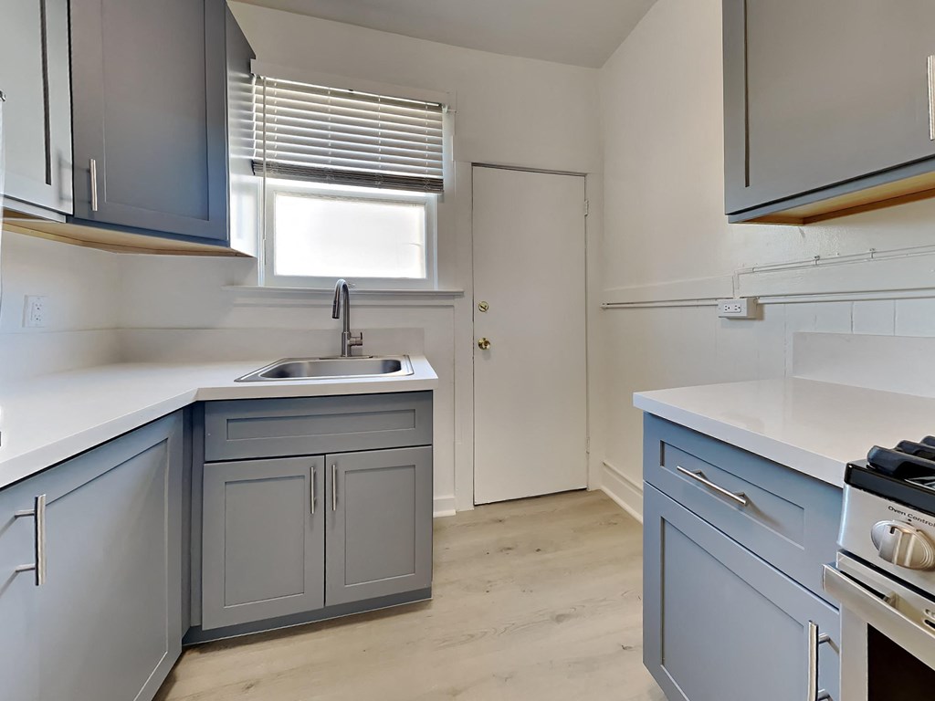 a kitchen with blue cabinets and a sink and a window