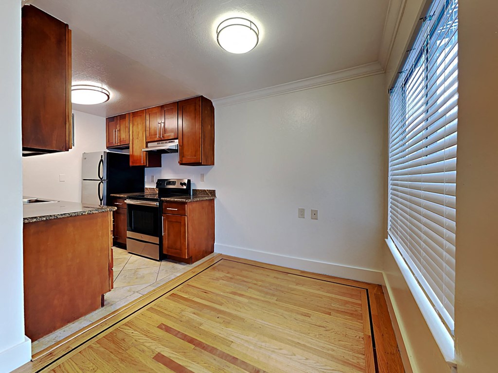 a kitchen with wood flooring and a large window