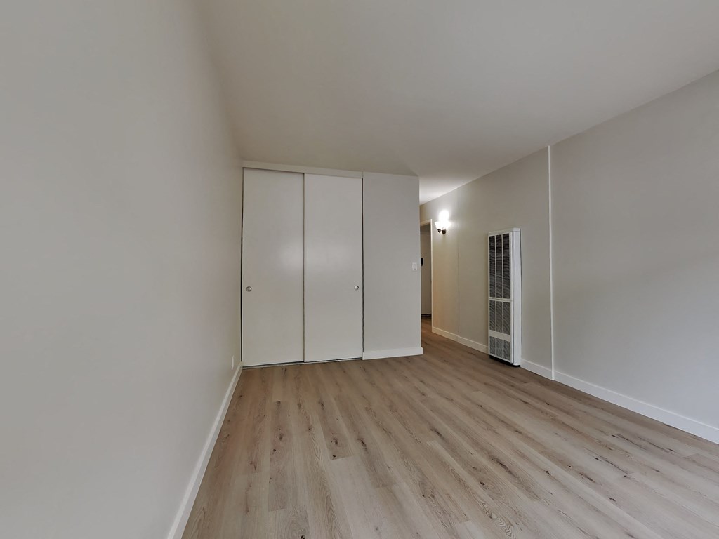 a renovated living room with white walls and wood floors