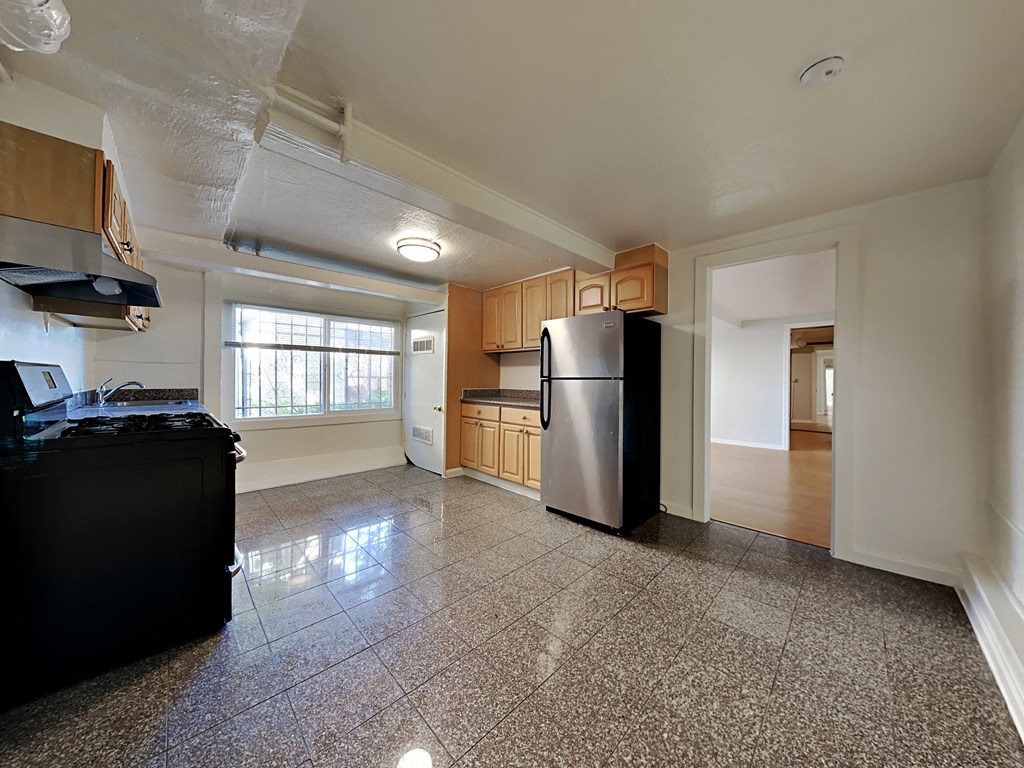an empty kitchen with a stainless steel refrigerator