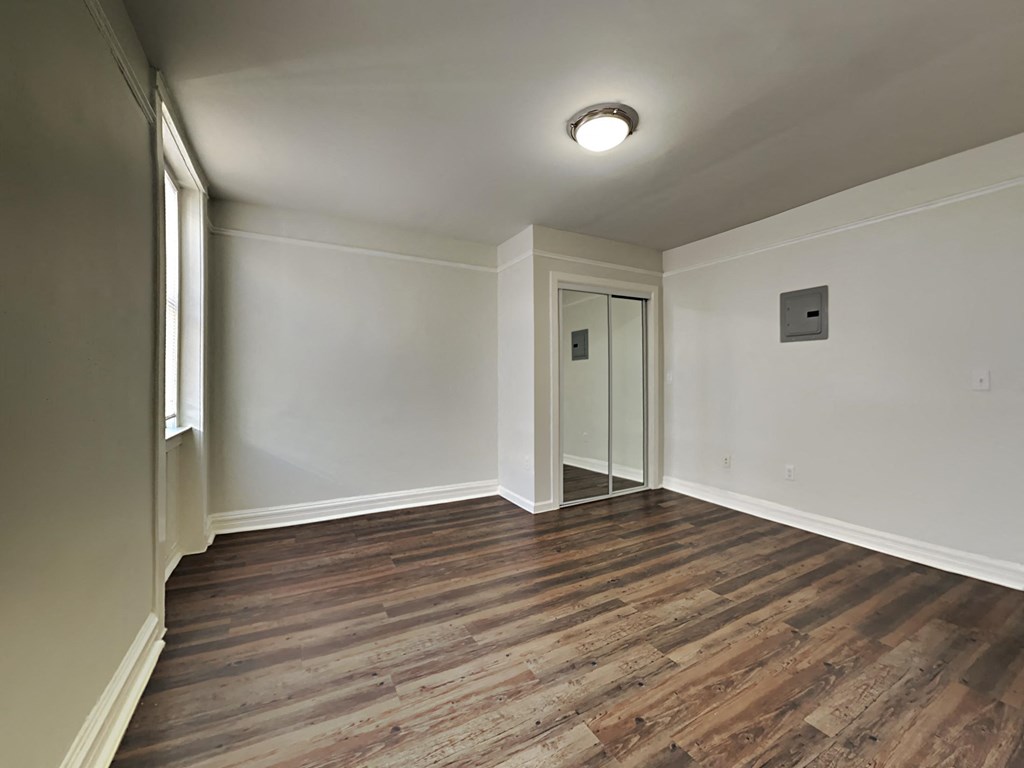 an empty living room with white walls and wood flooring