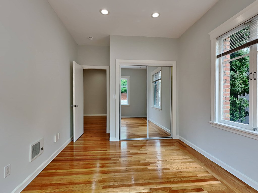 a living room with a hard wood floor and a large window