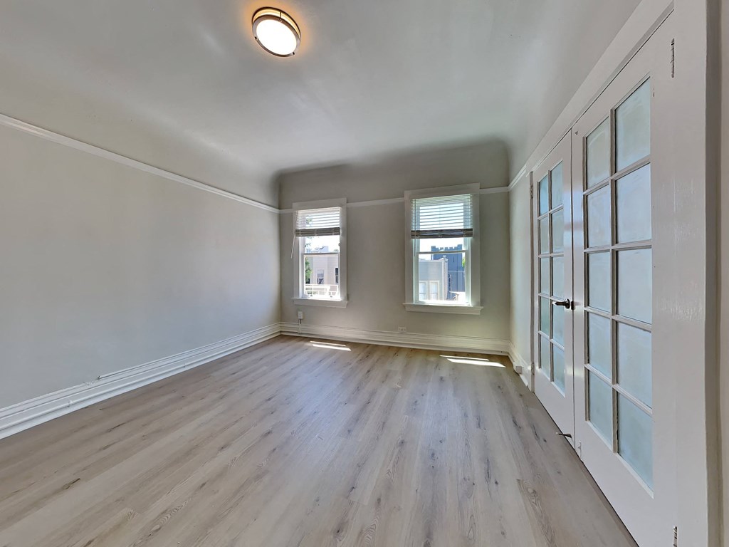 a living room with white walls and wood floors