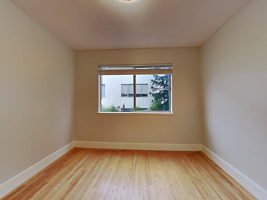 a room with a window and wooden floors