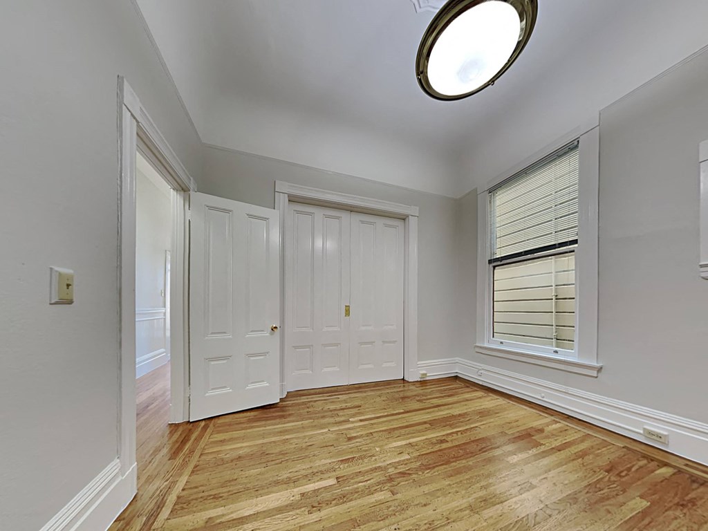 a living room with a window and a door and a wood floor