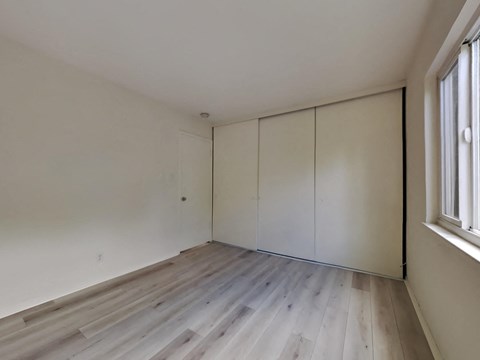 an empty room with white walls and wooden floors